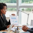 side-view-businesswoman-showing-analytical-charts-her-male-coworker